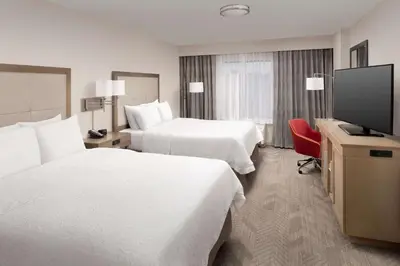 a hotel room with two beds and a flat screen tv at Hampton Inn & Suites Anaheim Garden Grove in Anaheim