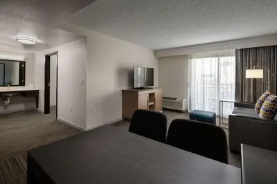a living room with a table and a couch and a television at Hampton Inn & Suites Anaheim Garden Grove in Anaheim
