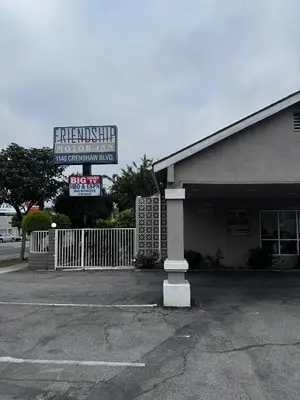 a building with a sign in the parking lot at Friendship Motor Inn in Los Angeles