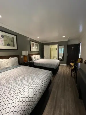 a hotel room with two beds and a desk at La Casa Inn in Pasadena