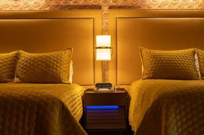a hotel room with two beds and a clock on a night stand at The Burgundy in Big Bear Lake