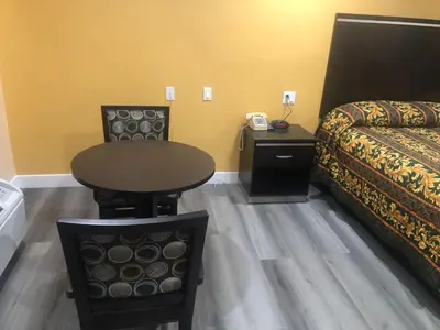 a room with a bed and a table next to a bed at Economy Inn near Ontario Airport - Chino in Ontario