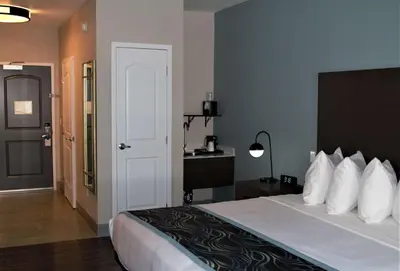 a hotel room with a large bed with white pillows at Best Western Plus New Barstow Inn & Suites in Barstow