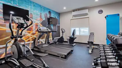 a gym with cardio equipment and a wall with a mural at Best Western Plus New Barstow Inn & Suites in Barstow