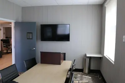 a room with a table and a tv on a wall at Best Western Plus New Barstow Inn & Suites in Barstow