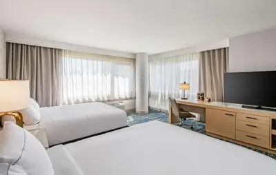 a hotel room with two beds and a desk with a television at DoubleTree by Hilton LAX - El Segundo in El Segundo
