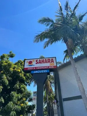 a sign for a seafood restaurant with palm trees at Sahara Inn - Los Angeles in Los Angeles