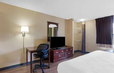 a hotel room with a bed and a desk with a television at Extended Stay America Suites - Orange County - Katella Ave in Orange