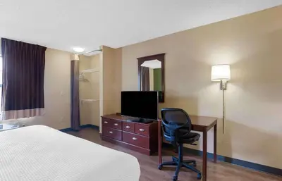 a hotel room with a bed and a desk with a television at Extended Stay America Suites - Orange County - Katella Ave in Orange