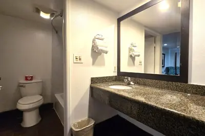 a bathroom with a sink and a toilet and a mirror at Century Motel Buena Park Anaheim I-5 in Buena Park