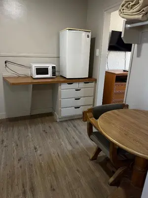 a kitchen with a table and a microwave on a counter at Apple Valley Motel in Apple Valley