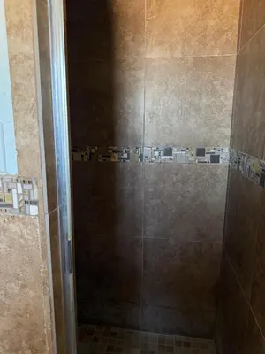 a shower in a bathroom with a glass door at Apple Valley Motel in Apple Valley
