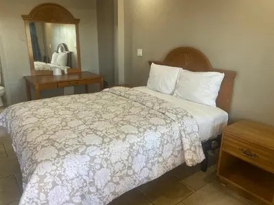 a hotel room with a bed and a mirror at Apple Valley Motel in Apple Valley