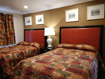 a hotel room with two beds and a lamp at Bartlett Motel in Lomita
