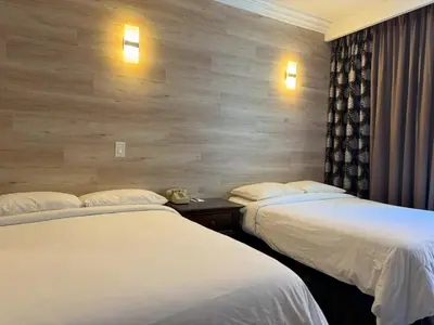 a hotel room with two beds and a wall at Garden Suite Hotel and Resort in Los Angeles