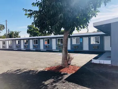 a blue building with a tree in front of it at New Casa Motel Los Angeles in Los Angeles