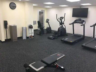 a gym with several exercise bikes and a flat screen tv at Best Western Plus Arrowhead Hotel in Colton