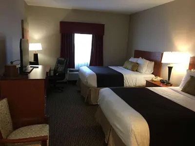 a hotel room with two beds and a television at Best Western Plus Arrowhead Hotel in Colton