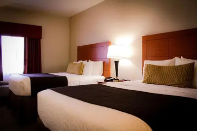 a hotel room with two beds and a lamp at Best Western Plus Arrowhead Hotel in Colton