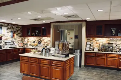 a large kitchen with wooden cabinets and a counter top at Best Western Plus Arrowhead Hotel in Colton