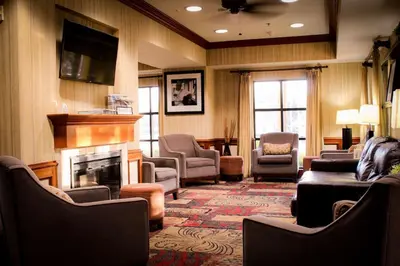 a waiting room with chairs and a fireplace at Best Western Plus Arrowhead Hotel in Colton