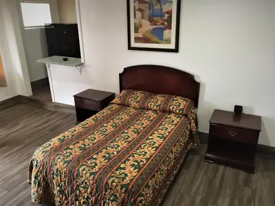 a hotel room with a bed and two night stands at Palm Inn Motel - Montclair in Montclair