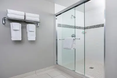 a bathroom with a glass shower stall with towels at The Pierpont Inn in Ventura