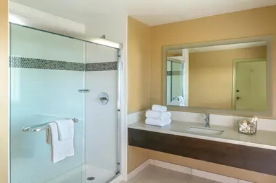 a bathroom with a shower and a sink and a mirror at The Pierpont Inn in Ventura