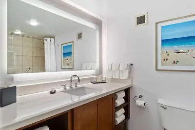 a bathroom with a sink and a large mirror at Embassy Suites by Hilton Anaheim South in Anaheim