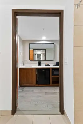 a kitchen with a sink and a mirror at Embassy Suites by Hilton Anaheim South in Anaheim