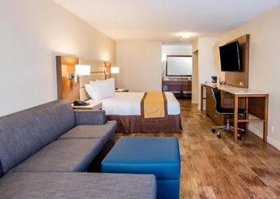 a hotel room with a bed and a couch and a desk at Travelodge by Wyndham Culver City in Los Angeles