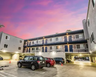 a parking lot with cars parked in front of a building at Travelodge by Wyndham Culver City in Los Angeles