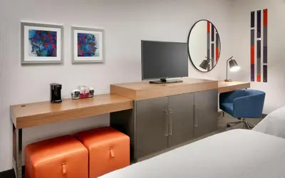 a bedroom with a desk with a tv and a mirror at Hampton Inn & Suites Anaheim Resort Convention Center in Anaheim