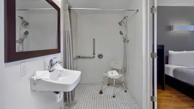 a bathroom with a sink and a shower and a bed at Motel 6 Victorville in Victorville
