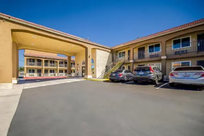 a parking lot in front of a hotel with cars parked at Quality Inn & Suites in Hesperia