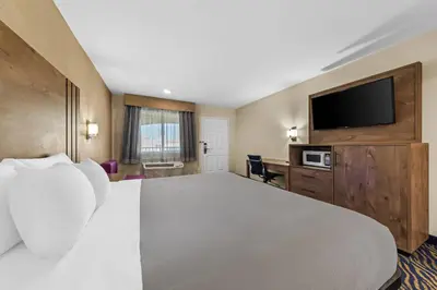 a hotel room with a large bed and a flat screen tv at Quality Inn & Suites in Hesperia