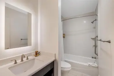 a bathroom with a sink and a toilet and a mirror at Best Western Plus LA Mid-Town Hotel in Los Angeles