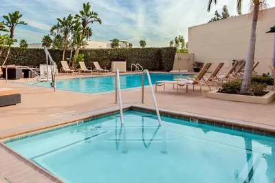 a swimming pool at a resort with lounge chairs at Holiday Inn La Mirada Buena Park by IHG in La Mirada
