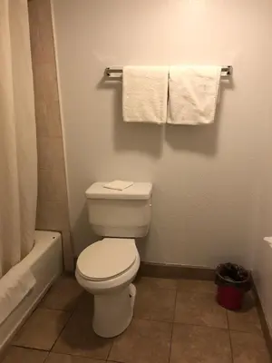 a bathroom with a toilet and a tub and towels at Starlight Inn, Valley Blvd - Downtown LA in Los Angeles