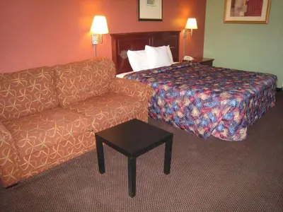 a hotel room with a couch and a bed at Motel 8 Maricopa in Maricopa