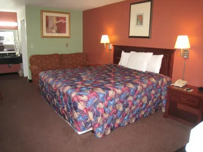 a hotel room with a bed and a couch at Motel 8 Maricopa in Maricopa