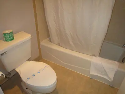 a bathroom with a white toilet and a bath tub at Motel 8 Maricopa in Maricopa