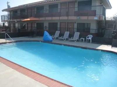 a large swimming pool in front of a building at Motel 8 Maricopa in Maricopa