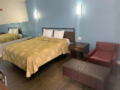 a hotel room with a bed and a chair at Crescent Inn in Wilmington