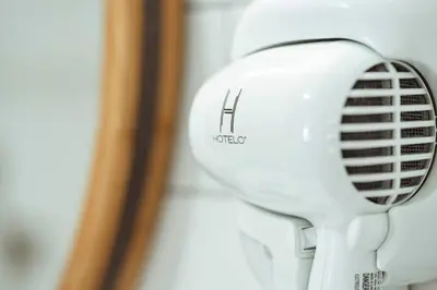 a white hair dryer hanging on a wall at The Belmont Shore Inn in Long Beach