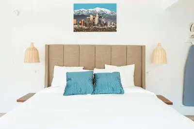a bedroom with a white bed with two blue pillows at The Belmont Shore Inn in Long Beach