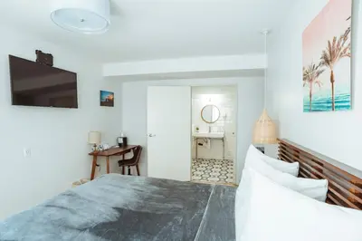 a bedroom with a large bed and a bathroom at The Belmont Shore Inn in Long Beach