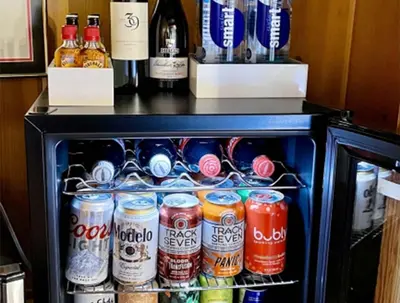 a refrigerator filled with lots of bottles of soda at Grand Pine Cabins in Wrightwood
