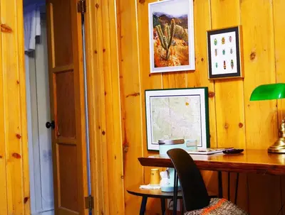 a desk with a computer on a wooden wall at Grand Pine Cabins in Wrightwood