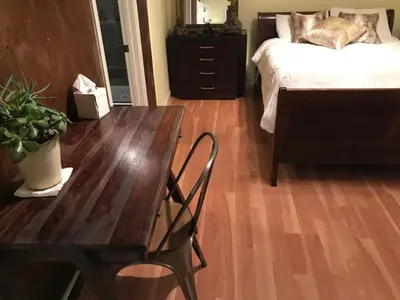 a bedroom with a wooden table and a bed and a table and chair at Cozy private Guest House in Los Angeles